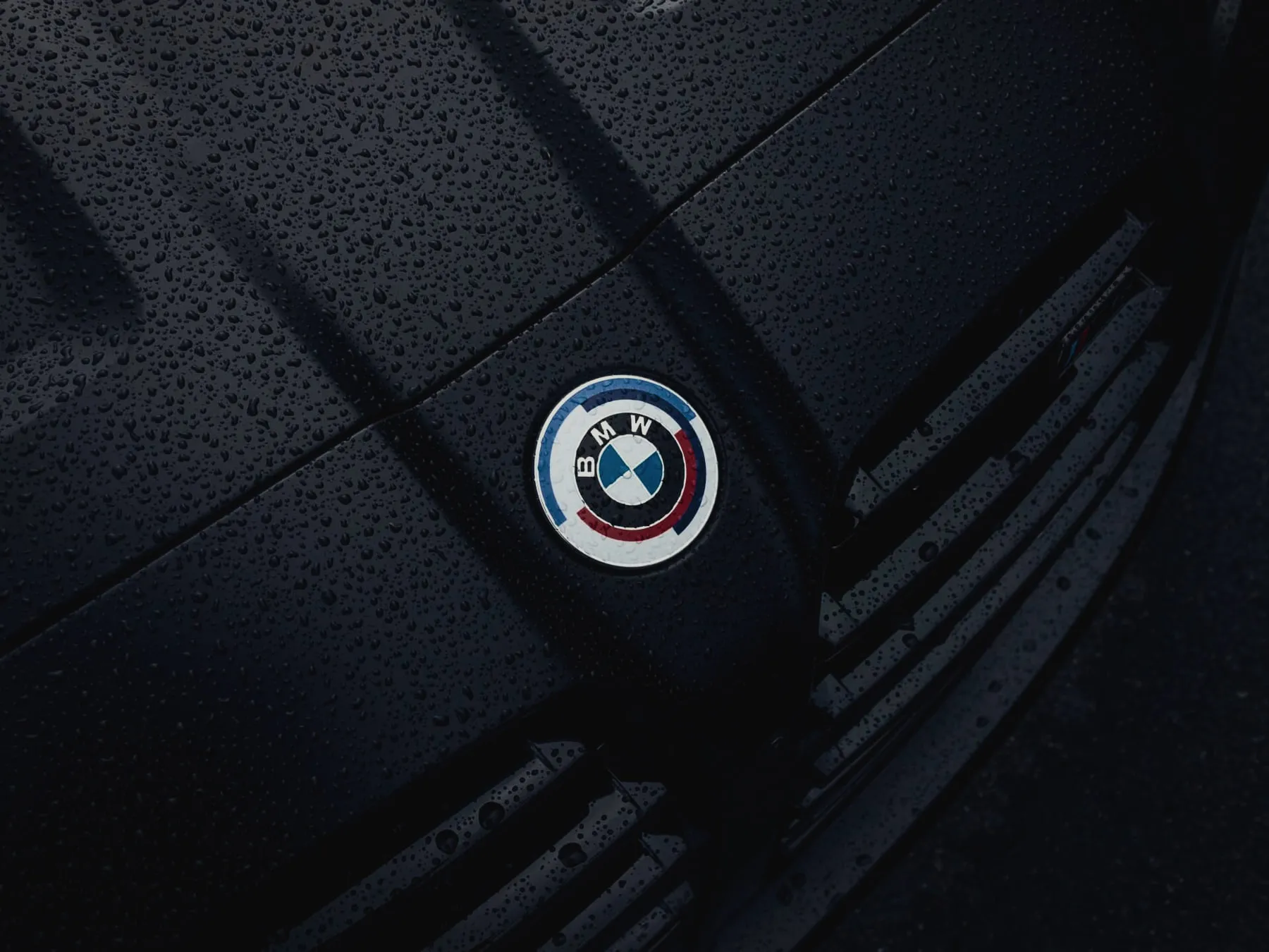 Water beading on a black BMW hood, the water-shedding effect of a ceramic coating