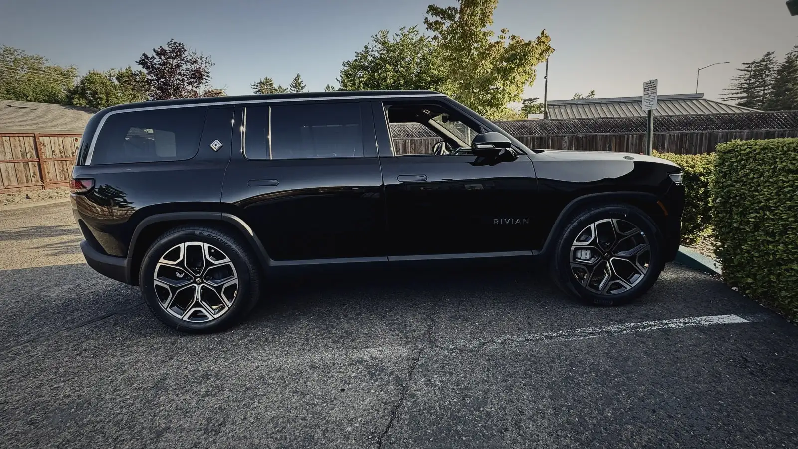 Black Rivian R1S in side profile in late-afternoon light