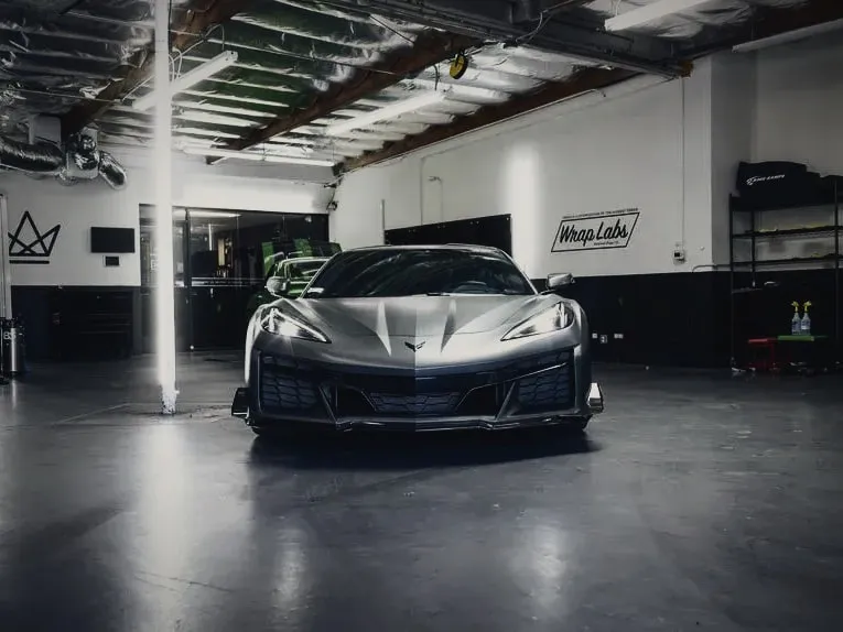 Windshield and low front splitter of a Corvette Z06, head-on in the Wrap Labs bay
