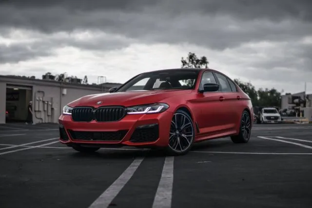 BMW 5 Series Matte Red Vinyl Wrap Front Three Quarter Parking Lot Overcast, by Wrap Labs, Westlake Village