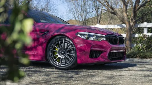 BMW M5 Fuchsia Pink Vinyl Wrap Front Quarter Wheel Yellow Brake Caliper Foliage Foreground