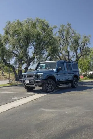 INEOS Grenadier Steel Blue PPF Front 3Quarter Vertical Parking Lot Trees, by Wrap Labs, Westlake Village