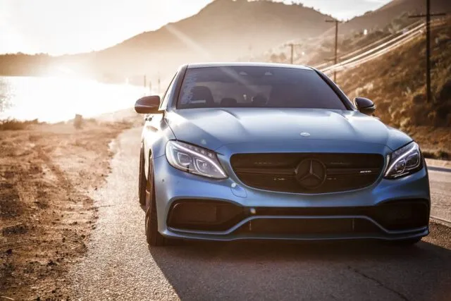 Mercedes AMG C63 Satin Blue Vinyl Wrap Front Head On Mountain Road Golden Hour