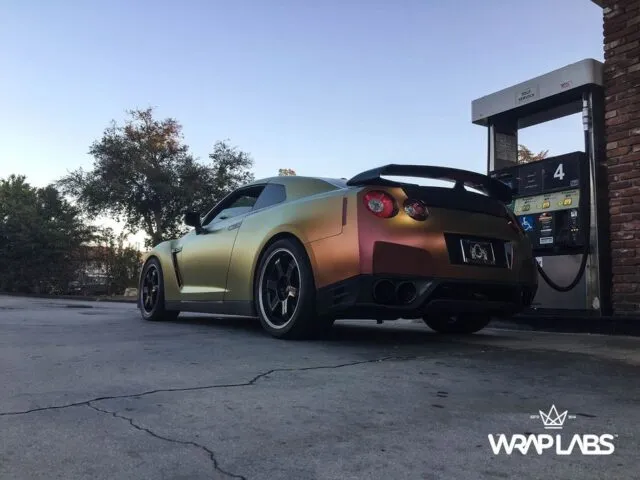 Nissan GT R Color Shift Gold Copper Vinyl Wrap Rear Three Quarter Gas Station