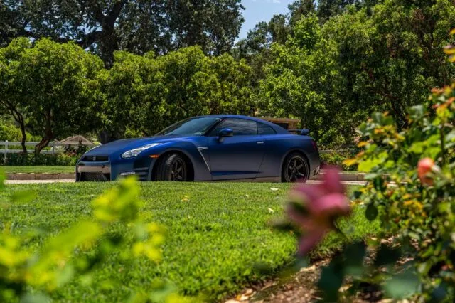 Nissan GT R R35 Matte Blue Vinyl Wrap Side Profile Garden Foreground v2