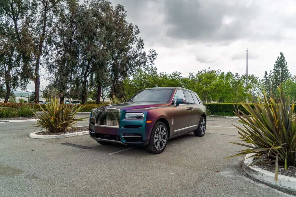 Rolls Royce Cullinan Color Shift Chameleon Vinyl Wrap Front 3Quarter Parking Lot Plants