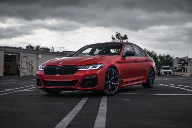BMW 5 Series Matte Red Vinyl Wrap Front Three Quarter Parking Lot Overcast, by Wrap Labs, Westlake Village