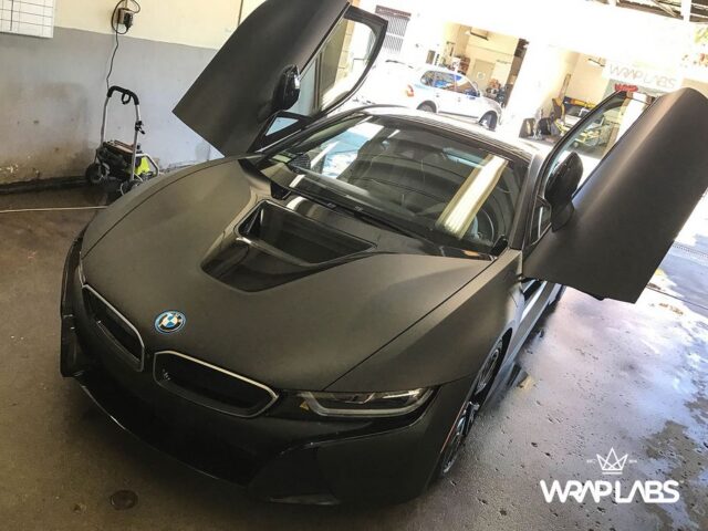 BMW i8 Matte Black Vinyl Wrap Scissor Doors Open Front Head On WrapLabs Shop Indoor, by Wrap Labs, Westlake Village