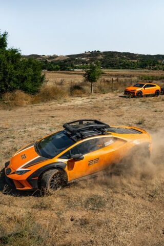 Lamborghini Huracan Sterrato Orange Vinyl Wrap Side Action Two Cars Dust, by Wrap Labs, Westlake Village