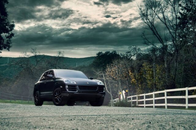 Porsche Cayenne Matte Black Vinyl Wrap Front Low Angle Dramatic Sky Ranch Fence, by Wrap Labs, Westlake Village